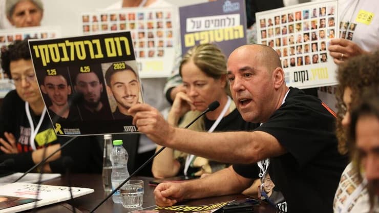 אופיר ברסלבסקי עם תמונת בנו (צילום: אלכס קולומויסקי) אופיר, אביו של החטוף רום ברסלבסקי בועדת חוץ וביטחון בכנסת