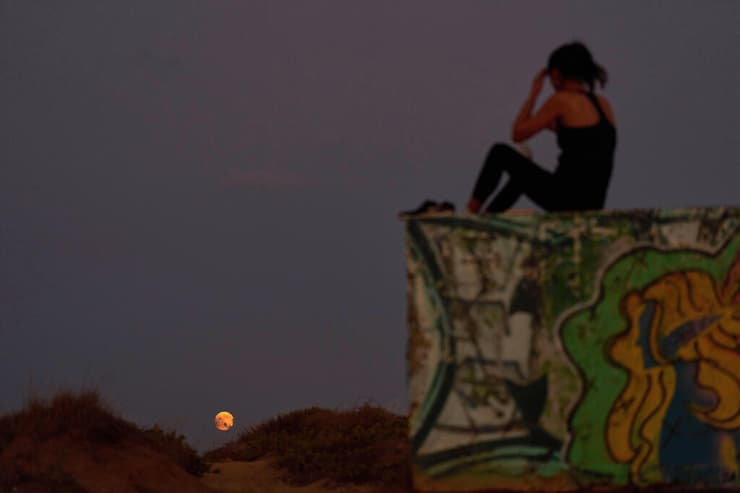 אישה צופה בליקוי בחדרה