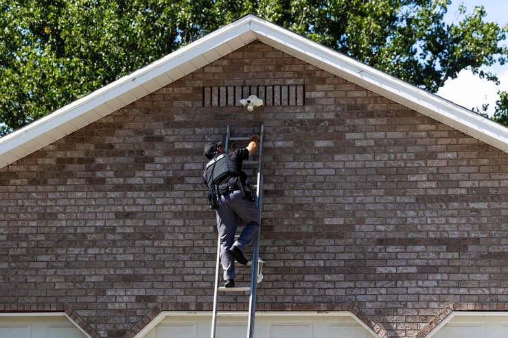 ארה"ב רצח צ'רלי קירק שוטר בודק מצלמת אבטחה ליד האוניברסיטה