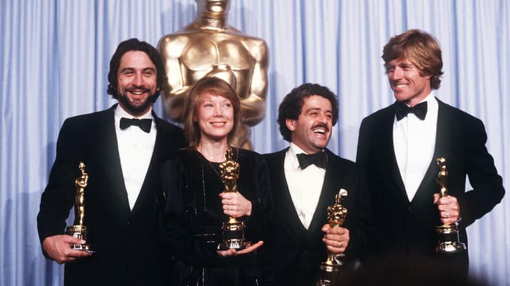 רוברט רדפורד (מימין), המפיק רונלד אל. שווארי, סיסי ספייסק ורוברט דה נירו בטקס האוסקר 1981 