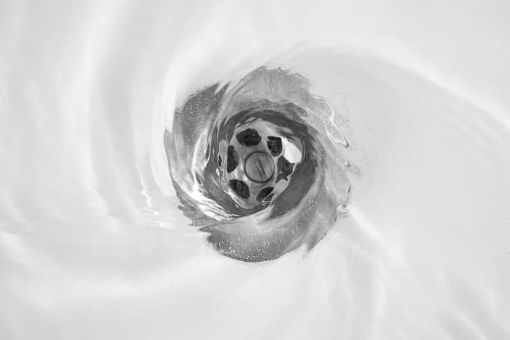 מים מסתובבים בכיור סביב פתח הניקוז