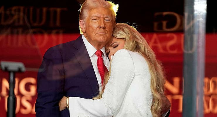 אריקה קירק, רעייתו של פעיל הימין שנרצח צ'רלי קירק, מחבקת את טראמפ בטקס המוני לזכר בעלה, 22 בספטמבר