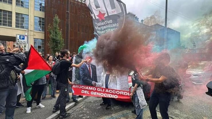 מפגינים שורפים תמונה של נתניהו ור"מ איטליה מלוני בטורינו מפגינים שורפים את תמונתו של נתניהו בטורינו