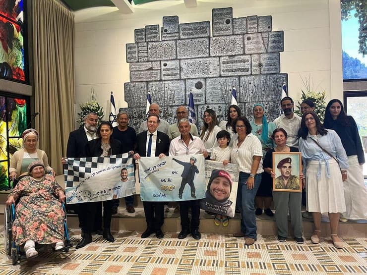 משפחת טוויג בבית הנשיא עם תמונותיהם של יפתח ז"ל ודודו, רחמים ז"ל   