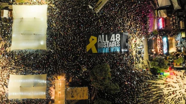 צילום: אבישי רייזנר פריסת דגל בעצרת משפחות החטופים בתל אביב