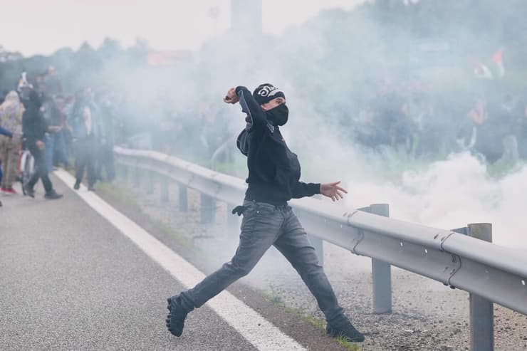 משליכים אבנים בהפגנה בכביש הטבעת במילאנו (צילום: AP Photo/Luca Bruno) מחאות פרו פלסטיניות באיטליה