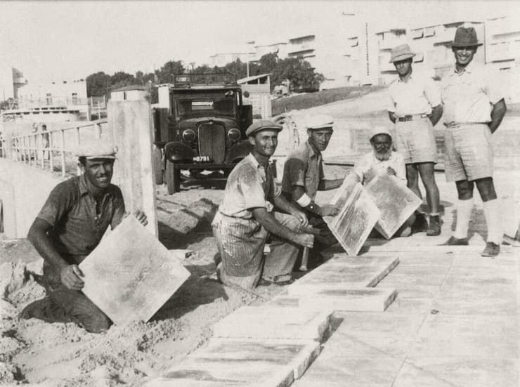 פועלים בונים את כיכר לונדון בתל אביב עם מרצפות של אקרשטיין