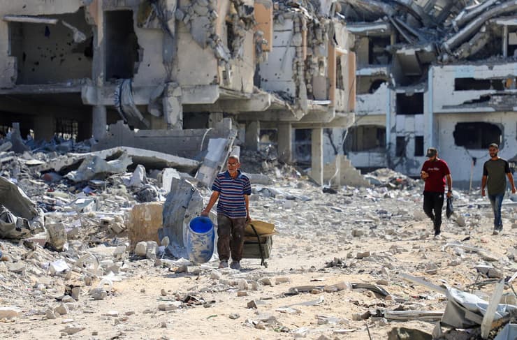 עקורים פלסטינים חולפים על פני הריסות
