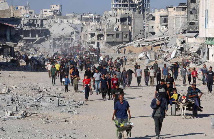 "מדינות רבות מעוניינות לתמוך בהקמת הכוח". פלסטינים חוזרים לבתיהם בחאן יונס אחרי נסיגת צה"ל, בשבוע שעבר (צילום: REUTERS/Ramadan Abed) עקורים פלסטינים חולפים על פני הריסות