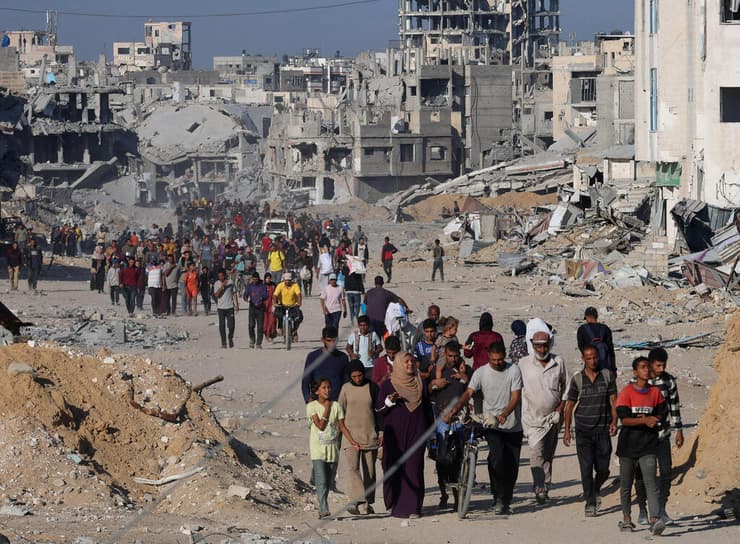 עקורים פלסטינים חולפים על פני הריסות