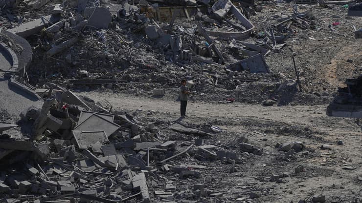 עקורים פלסטינים חולפים על פני הריסות