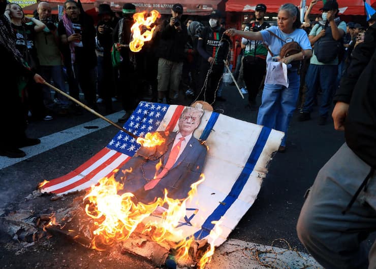 מפגינים שורפים את דגלי ישראל וארצות הברית ואת תמונתו של טראמפ במדיין, קולומביה, ב-7 באוקטובר 2025