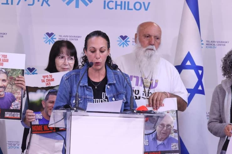 לישי לביא מירן, ומאחוריה המשפחות נושאות שלטים עם תמונות החללים החטופים (צילום: מוטי קמחי) הצהרת משפחות שורדי השבי באיכילוב