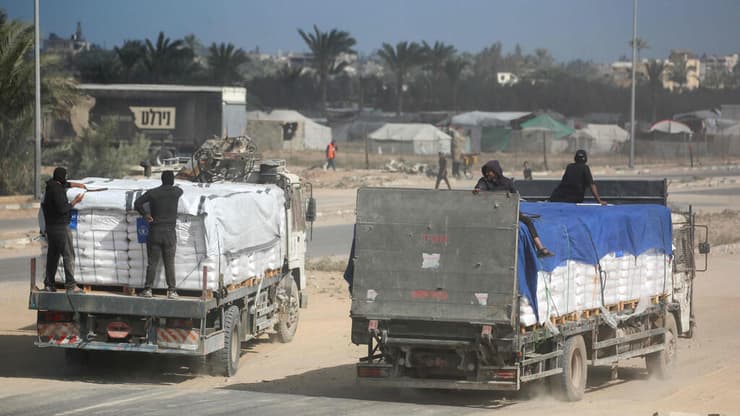 משאיות סיוע בדיר אל-בלח (צילום: Bashar TALEB / AFP) דיר אל בלח עזה משאיות סיוע המוניטרי