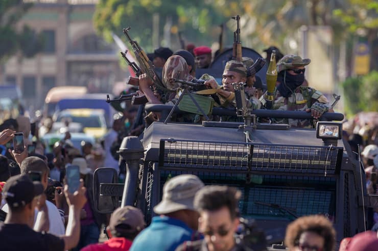 חיילי יחידת CAPSAT בדרך לארמון הנשיאות ביום שלישי, כשההמון חוגג (צילום: AP Photo/ Brian Inganga) חיילים שלקחו חלק ב הפיכה צבאית ב מדגסקר בבירה אנטננריבו בדרך לארמון הנשיאות 14 באוקטובר