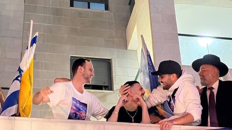 אלקנה בוחבוט לקהל ממרפסת ביתו. "תודה לכם, אתם עם נפלא" (צילום: לירן תמרי) אלקנה בוחבוט בביתו