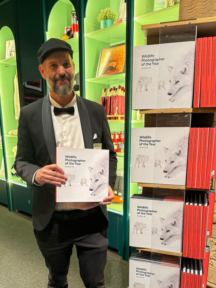 צלם הטבע עמית אשל מציג את הספר השנתי של התחרות "צלם הטבע של השנה", שעל כריכתו מופיעה תמונת הזאבים הארקטיים שצילם (צילום: באדיבות עמית אשל) צלם הטבע עמית אשל מציג את הספר השנתי של התחרות "צלם הטבע של השנה", שעל כריכתו מופיעה תמונת הזאבים הארקטיים שצילם