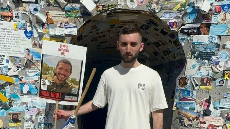 מתן אנגרסט עם תמונת החטוף של איתי חן בכיכר החטופים מתן אנגרסט בביקור ראשון בכיכר החטופים