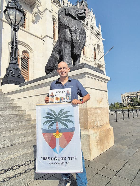 קורח ותמונות חללי הגדוד. "להפוך לזה שמטפלים בו" (צילום: ליאור בן עמי) אייל כורח עם תמונות חללי הגדוד