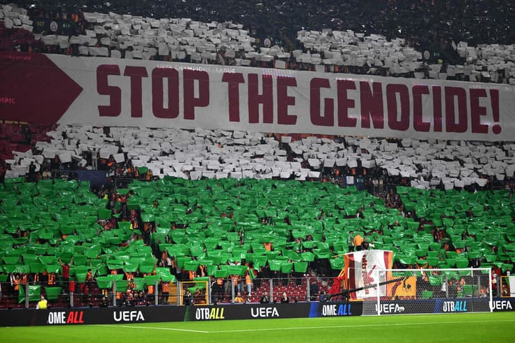 אוהדי גלאטסראיי עם תפאורה של דגל פלסטין ושלט נגד ישראל (צילום: YASIN AKGUL / AFP) אוהדי גלאטסראיי עם תפאורה של דגל פלסטין ושלט נגד ישראל