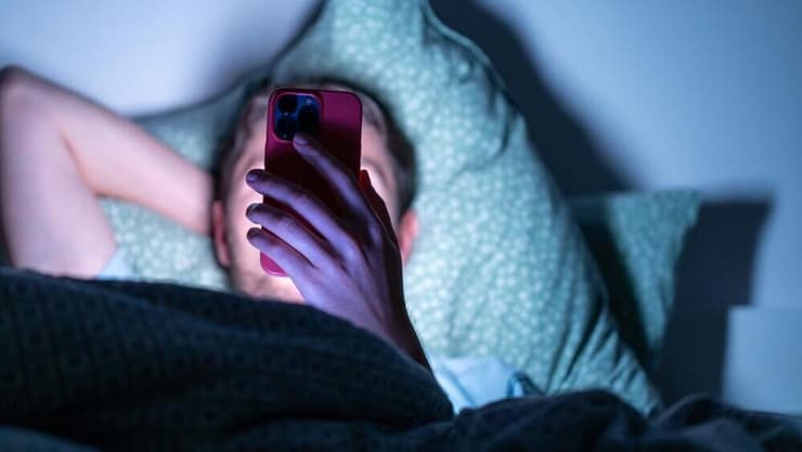 האור שנפלט מהמסך מפריע להירדמות ומשבש את השינה (צילום: Shutterstock) טלפון נייד, גלילה, שינה, הירדמות