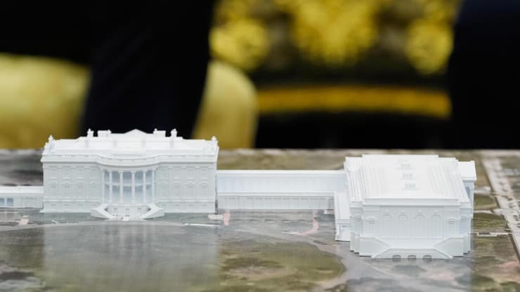 דגם מוקטן של אולם הנשפים (מימין למבנה המוכר והמרכזי של הבית הלבן), שטראמפ הציב על שולחנו בחדר הסגלגל (צילום: AP Photo/Alex Brandon) דגם של הבית הלבן ו אולם נשפים חדש ש נשיא ארה"ב טראמפ בונה שהוצב ב החדר הסגלגל