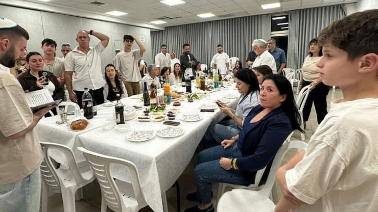 מתן אנגרסט בקידוש עם משפחתו (צילום: מטה משפחות החטופים) חגי אנגרסט בקידוש עם משפחתו
