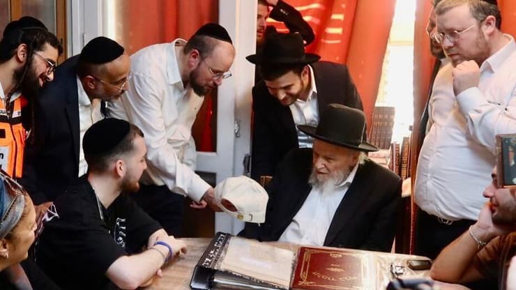 בר קופרשטיין בבני ברק, היום. "תמיד בידיים של בורא עולם" על הכובע (צילום: שוקי לרר) מראים לרב את הכובע "בר תמיד בידיים של בורא עולם"