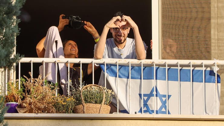 אביתר דוד מסמן לב ממרפסת ביתו בכפר סבא (צילום: יריב כץ) קבלת פנים לאביתר דוד בכפר סבא