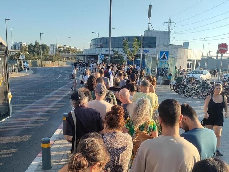 משתתפים בעצרת למען השבת החטופים מחכים לרכבת משתתפים בעצרת למען השבת החטופים מחכים לרכבת