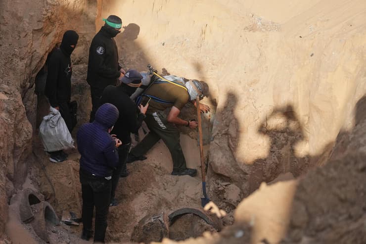 עם בלוני חמצן על הגב. מחבלי חמאס עורכים לכאורה חיפוש אחר חללים חטופים במנהרה בשכונת חמד שבחאן יונס (צילום: AP Photo/Jehad Alshrafi) מחבלי חמאס עורכים לכאורה חיפוש אחר חללים חטופים בשכונת חמד חאן יונס