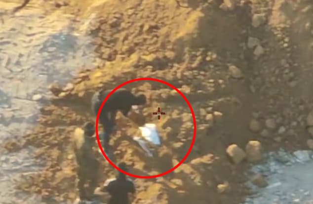 המחבלים "שולפים" את השקית מתוך ערימת החול אנשי חמאס מביימים הימצאות שרידי גופת חלל, בנוכחות אנשי צלב אדום