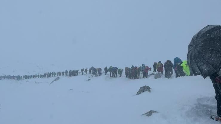 מטיילים יורדים מההר בסופה (צילום: שאיאן מאירה מאורי, מגנוס) סופת שלג בנפאל