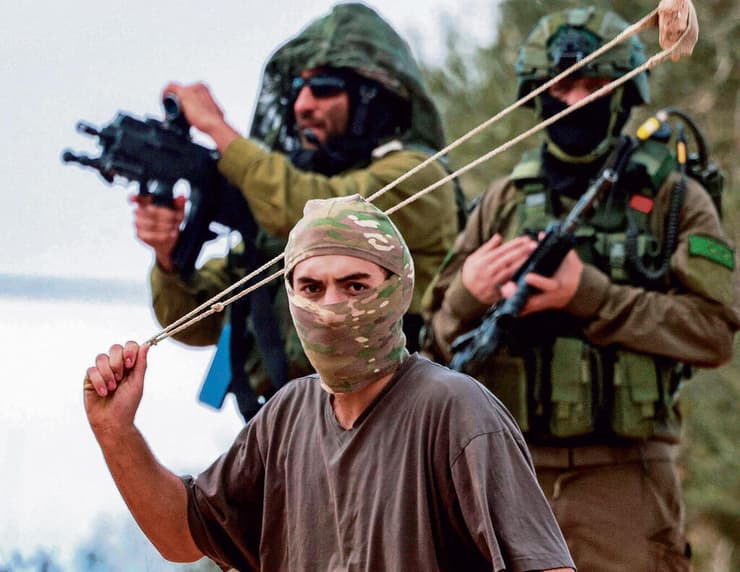 נער גבעות מיידה אבן בעימות בכפר ביתא. "במקרה הטוב החיילים לא עושים כלום מול האלימות ובמקרה הרע לוקחים בה חלק" (צילום: אי-אף-פי, JAAFAR ASHTIYEH) yk14563561