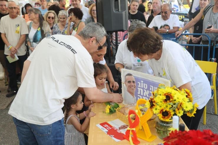 "כמה טוב שבאת הביתה". השולחן שהוכן לעמרי (צילום: מוטי קמחי) קבלת שבת של קהילת נחל עוז בכיכר החטופים בהשתתפות שורד השבי עמרי מירן
