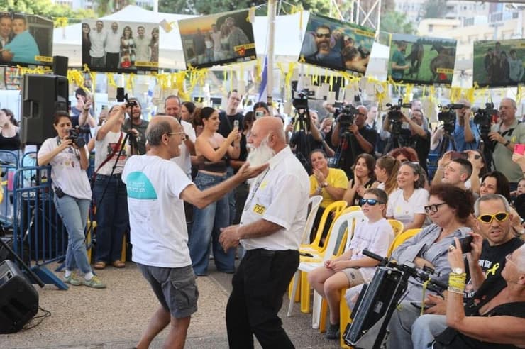דני מירן רוקד עם חברי קהילת נחל עוז. "בכל שישי עמדתי ודיברתי פה, היום סגרתי מעגל" (צילום: מוטי קמחי) קבלת שבת של קהילת נחל עוז בכיכר החטופים בהשתתפות שורד השבי עמרי מירן