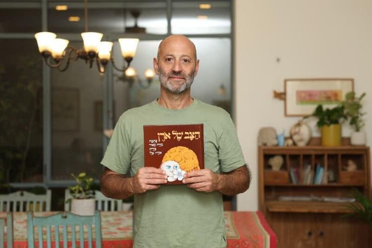 אורן מאיר והספר שנכתב עליו (צילום: דנה קופל) אורן עם הספר המתוקן