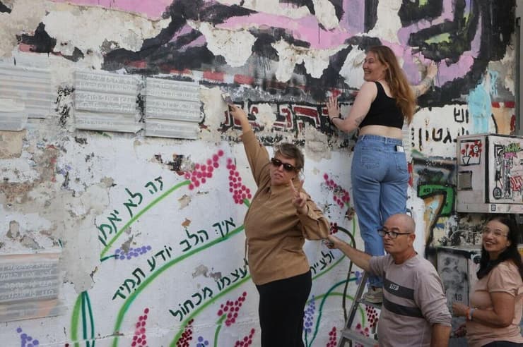 "זה לא אני מול ציור שהשחיתו לי, זו השכונה כולה ואנשים שעוברים פה". מתנדבים מנקים את הקיר לקראת השחזור (צילום: מוטי קמחי) צוות של מתנדבים החל בתהליך שחזור הציור של רצח רבין בשכונת פלורנטין בתל אביב