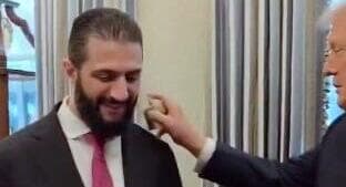 טראמפ מרסס בושם על נשיא סוריה אחמד א-שרע בביקור שערך בבית הלבן, 10 בנובמבר