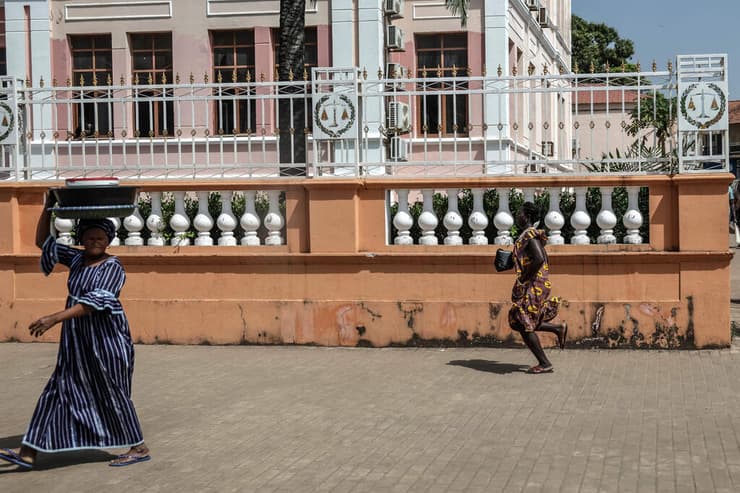 גינאה ביסאו הפיכה אישה בורחת מזירת ירי ליד ארמון הנשיאות ב ביסאו
