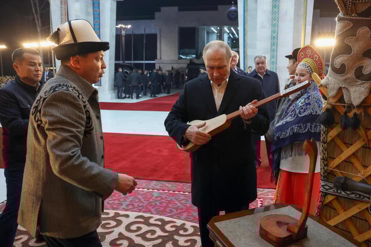 צילום:Alexander Kazakov, Sputnik, Kremlin Pool Photo via AP נשיא רוסיה פוטין עם כלי מיתר מקומי במהלך ביקור ב קירגיזסטן