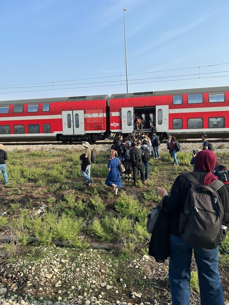 נוסעים עוזבים את קרון הרכבת שעצרה  באמצע הדרך