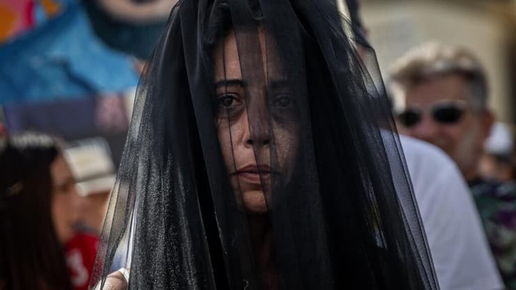 בקריאה נואשת לשחרור בנה החטוף מתן צנגאוקר עטתה עינב צנגאוקר הינומה שחורה במהלך טקס חתונה מבוים שנערך בכיכר החטופים בהשתתפות בת זוגו של מתן, שורדת השבי אילנה גריצ'ווסקי. תל אביב, 17 באוגוסט 2025 (צילום: שיר טורם, רויטרס) בקריאה נואשת לשחרור בנה החטוף מתן צנגאוקר עטתה עינב צנגאוקר הינומה שחורה במהלך טקס חתונה מבוים שנערך בכיכר החטופים בהשתתפות בת זוגו של מתן, שורדת השבי אילנה גריצ'ווסקי. תל אביב, 17 באוגוסט 2025