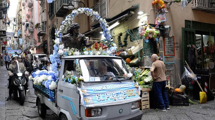 אוהדים מסיעים פסל של דייגו ארמנדו מראדונה ברחובות נאפולי