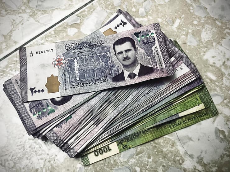 שטרות כסף עם תמונת הנשיא המודח בשאר אל־אסד