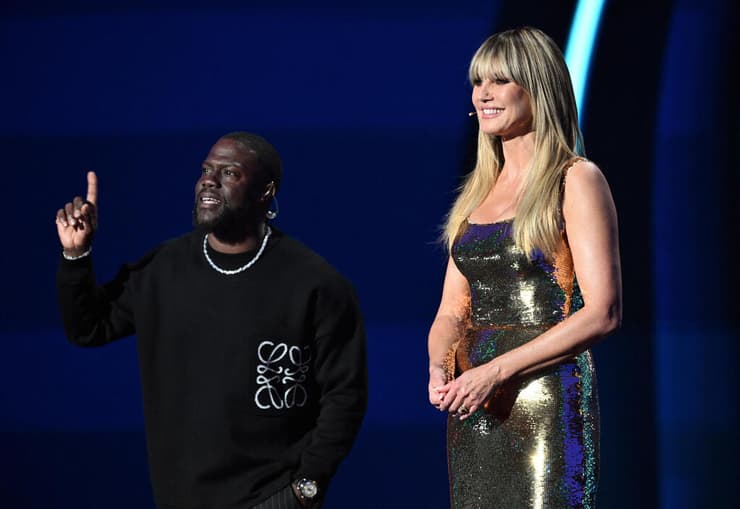 קווין הארט עם היידי קלום בהגרלת שלב הבתים של המונדיאל