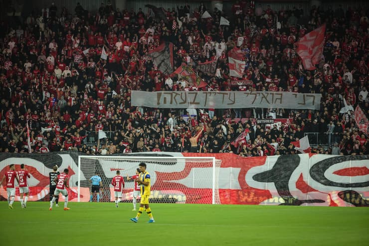 אוהדי הפועל הפועל באר-שבע מניפים שלט לכבוד רני גואילי שגופתו מוחזקת בעזה (צילום: עוז מועלם ) הפועל באר-שבע - מכבי ת"א טקס להשבת רני גואילי שגופתו מוחזקת בעזה