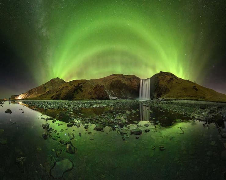 A Cathedral of Green Light Rising Over Skógafoss – סקוּגפוס, איסלנד (Victor Lima / The 2025 Northern Lights photographer of the year) צילומי הזוהר הצפוני היפים בעולם