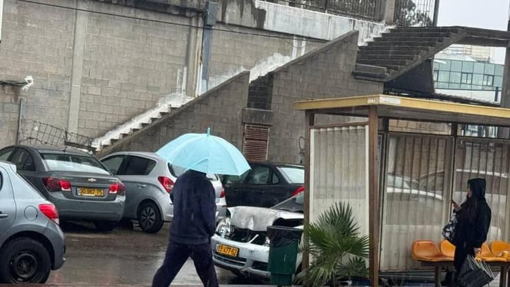 הכינו את המטריות (צילום: איתן גליקמן ) אור עקיבא: תושב המקום בגשם הסוער עם מטרייה וכפכפים - סופת ביירון