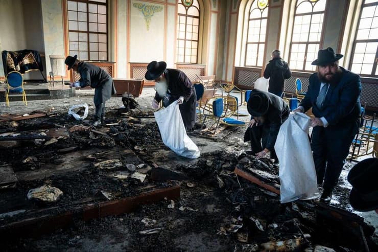 אוספים את שרידי ספרי הקודש (צילום: יהושע פרוכטר ומאיר זלזניק) אוספים את שרידי ספרי הקודש